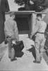 Photographic officers of the 390th Bomb Group deliver combat film to the laboratory for processing. Image stamped on reverse: ‘Keystone Press.’ [stamp], ‘Passed for publication 27 Aug 1943.’ [stamp] and ‘281017.’ [Censor no.] Printed caption on reverse: 'PHOTO MEN SERVE WITH FLYING FORTRESSES. When it comes to bombing, pictures tell the story. Skilled photographers serving with the U.S. 8th Air Force Flying Fortress Group are trained to get the pictures, process them and send prints and negatives to higher Headquarters - all on split-second schedule. Automatic cameras are installed in the Forts before take-off, each equipped with an intervalometer. Over the target the 'plane's radio operator merely flick a switch ... the camera does the rest, swapping consecutive shots at predetermined intervals. On return, photo men are on hand to meet the Forts. Films are rushed by Jeep to the Photo Laboratory, processed at high speed, then dispatched to Wing H by special courier. But mission shots are only ... of the photo section. It also handles everything from public relations and engineering to battle damage and identification pictures. This series of pictures shows the men of the Photo section of a Flying Fortress Group at work . U.S. Pool/F.KEYSTONE SG. Arriving at the Laboratory with exposed film.'